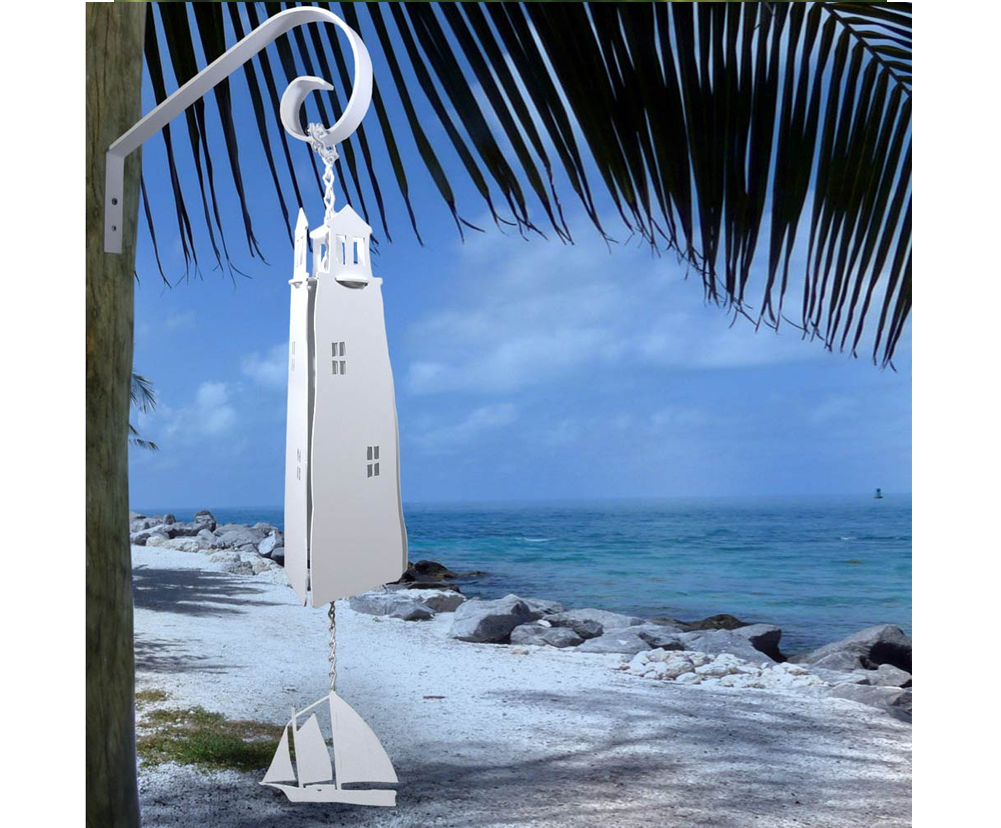 windchime of a lighthouse and sailboat against an ocean view
